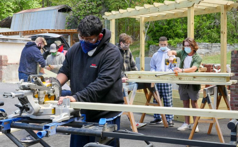 five students outside working on carpentry