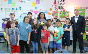 A class photo of Ms. Torey Owens, Superintendent Mark Garrett and 10 students.